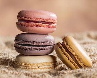 4 macarons dont 3 empilés, sur toile de jute et fond marron clair