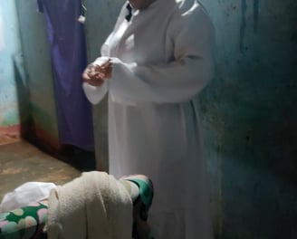 Pessoa vestida de branco se prepara para o ritual dos penitentes em ambiente simples e escuro