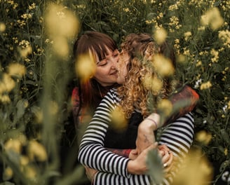 Lesbisches Paar küsst sich im Gras