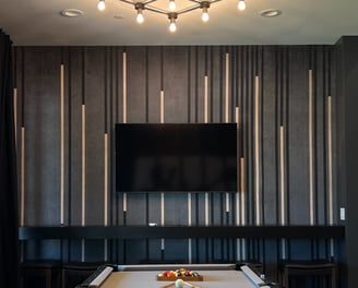 Modern accent wall featuring black, gold, and gray vertical wood slats against gray limewash