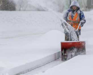 a man is using a snow blower to clear the snow