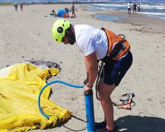 Allievo principiante intento a gonfiare una vela di kitesurf