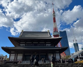 a large building with stairs and a tower in the background