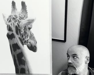 A photo of Will Arden with a drawing of a giraffe