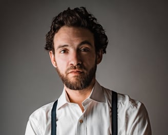 Portrait en studio homme qui croise les bras, en chemise et bretelles - book comédien - © Virginie Bouilhac