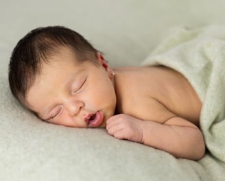 Sessió de fotos newborn a Girona amb una bebè recent nascuda dormint en estudi fotogràfic