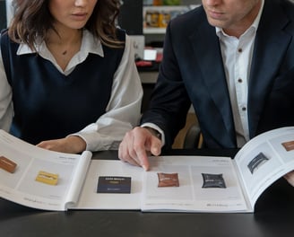 a man and woman sitting at a table with a catalogue of Chinese products