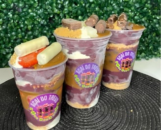 three cups of fruit and yogurt in a cupcake