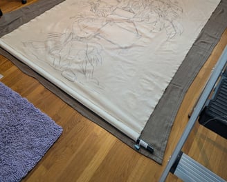 Linen tapestry laying on a clean surface on the floor for measuring and stretching.