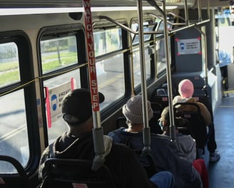 Photo of people on a bus from the back of the bus