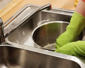 kid washing dishes in the sink