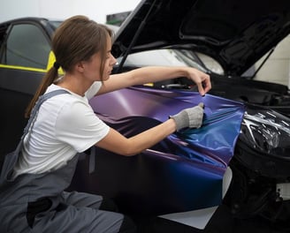a woman worker is customizing a cars color at fix collision center