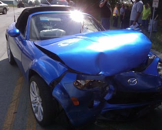 a blue car with a damaged front bumper getting fixed at fix collision center