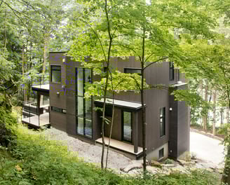 a house with a large tree in the middle of a wooded area, the exterior of Lakefront/Lake Champlain