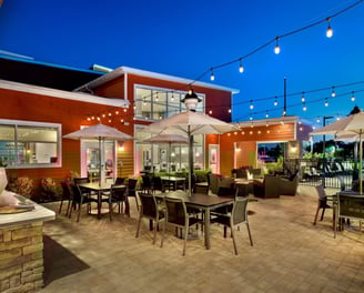 a patio with tables and umbrellas