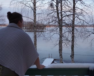 a woman standing on a balcony railing looking out over a lake