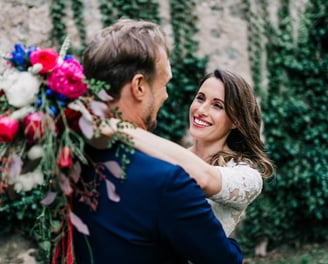 a bride and groom are smiling and hugging each other