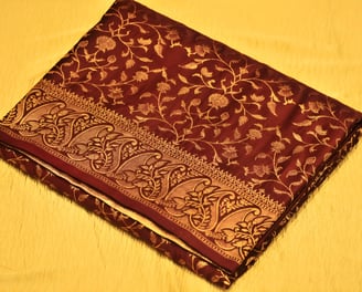 Luxurious maroon Banarasi silk saree adorned with intricate gold zari work, ideal for grand occasion