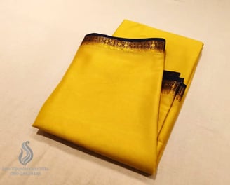 Bright yellow silk saree with elegant gold and black border, perfect for festive occasions.