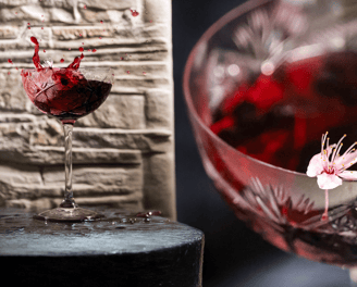 Calice di vino rosso in splash creativo fotografato da Gaudife a Bologna – still life emozionale per brand artigianali.