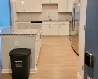 a kitchen with a trash canister and trash canisters
