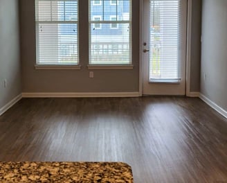 Clean and polished hardwood-style floor in a modern apartment living area.