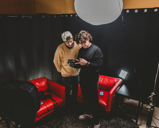 Two men in a podcast studio setting up podcast production services.