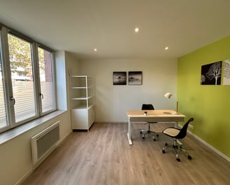 Bureau au rez-de-chaussée de chaussé équipé avec mobilier et une grande fenêtre