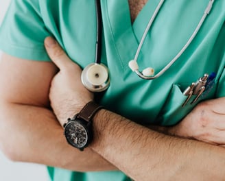 a man in a green scrubsuit with a stethoscope attached to his