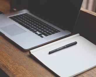 a pen and notebook on a desk. Key tools for Content Writing. 