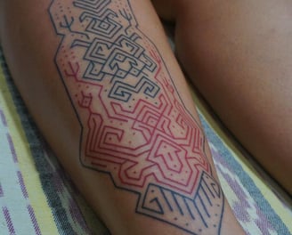 An handpoke tattoo featuring art ornaments symmatrical geomatric lines tappis hand weaving inspired.