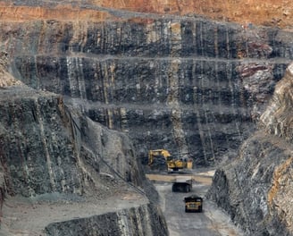 a large amount of rock is being worked on by a truck
