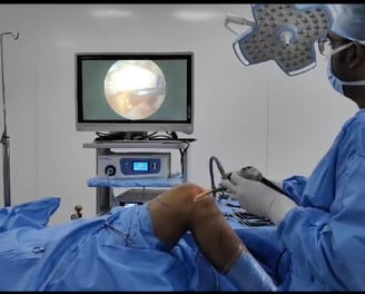 Surgeon performing minimally invasive arthroscopic surgery on a patient's knee.