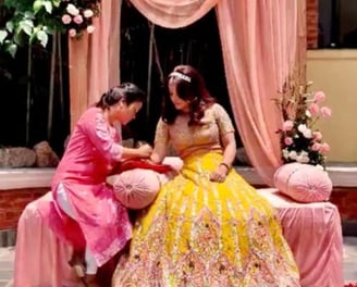 Henna artist doing henna on groom"s hand during mehendi ceremony