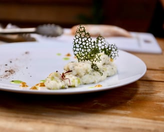 A plate with creamy risotto and green decoration