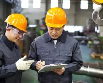 two men in hard hats and hard hats are standing in hongmeng tractors factory