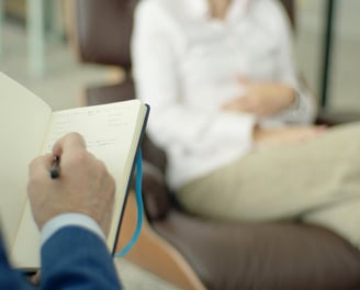 a man and woman sitting in chairs in a waiting room