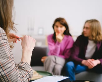a woman in a plaid shirt is sitting in a group of people