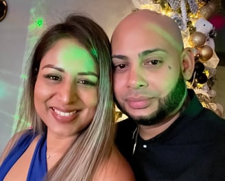a man and woman standing next to a christmas tree