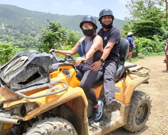 a man and woman riding on a quad - bike