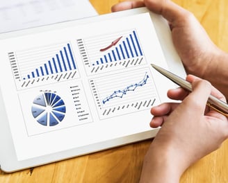 A person holding a tablet and other person is using a pen to explain the details of his investments