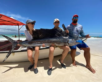 Fishing in Zanzibar for beginners - A guide helping a tourist with their first catch.