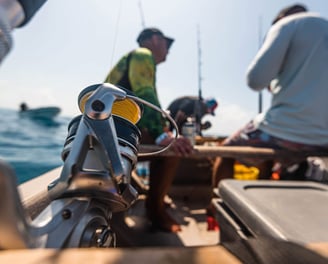 A close-up of fishing gear, including rods, reels, and bait, on a boat in Zanzibar.