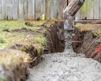 a concrete slab being poured into a trench