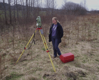 a woman in a field with a tripod and a tripod