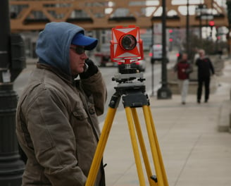 a man in a blue jacket and a camera on a tripod