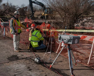 a man in a yellow vest and a camera on a tripod