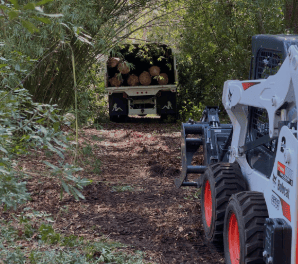 a tractor with a loader on it's back in the woods