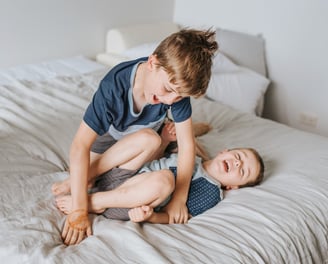 Two children play wrestling and smiling