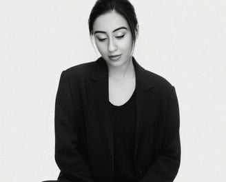 a wedding photoghrapher sitting on a stool with her eyes closed